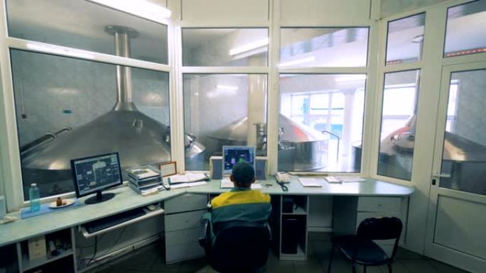 男技术员正在他的办公室控制酒精生产过程