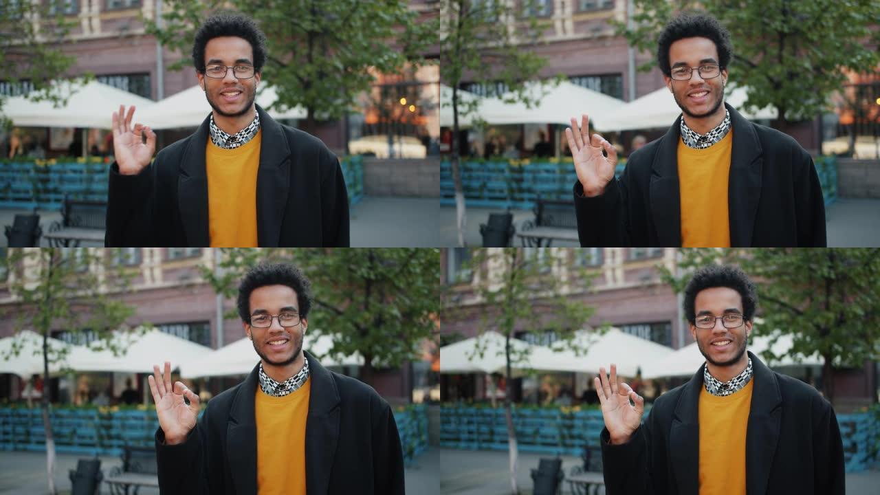 快乐的非洲裔美国男子站在街上微笑着示意