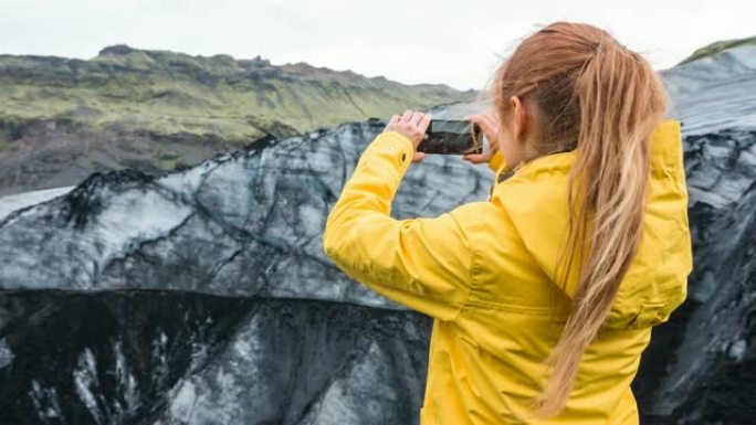 用智能手机拍摄冰岛冰川覆盖火山灰的女人