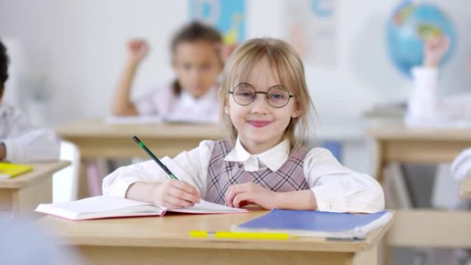 戴眼镜的可爱女学生在课堂上摆姿势