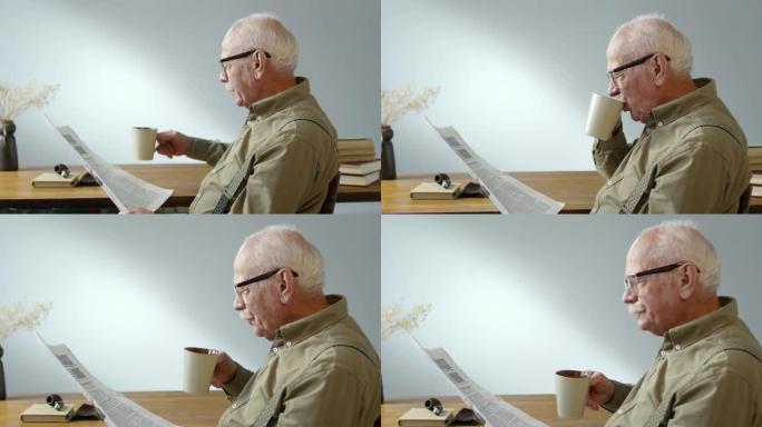 高年级男子喝咖啡看报纸