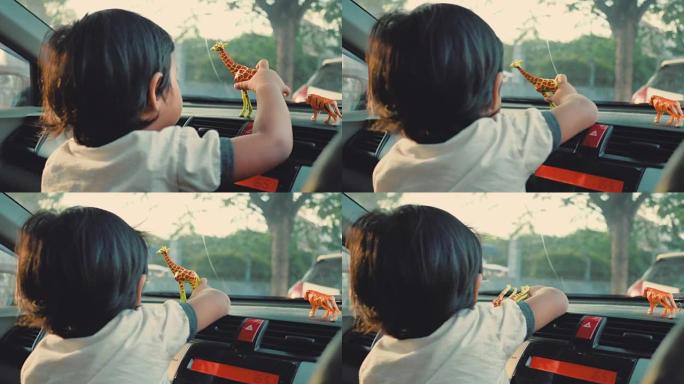 快乐的小男孩坐在车里玩玩具。