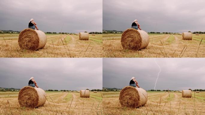 当闪电击中天空时，DS担心的女人坐在草捆上