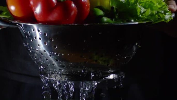 手拿漏勺和湿蔬菜清水洗蔬菜
