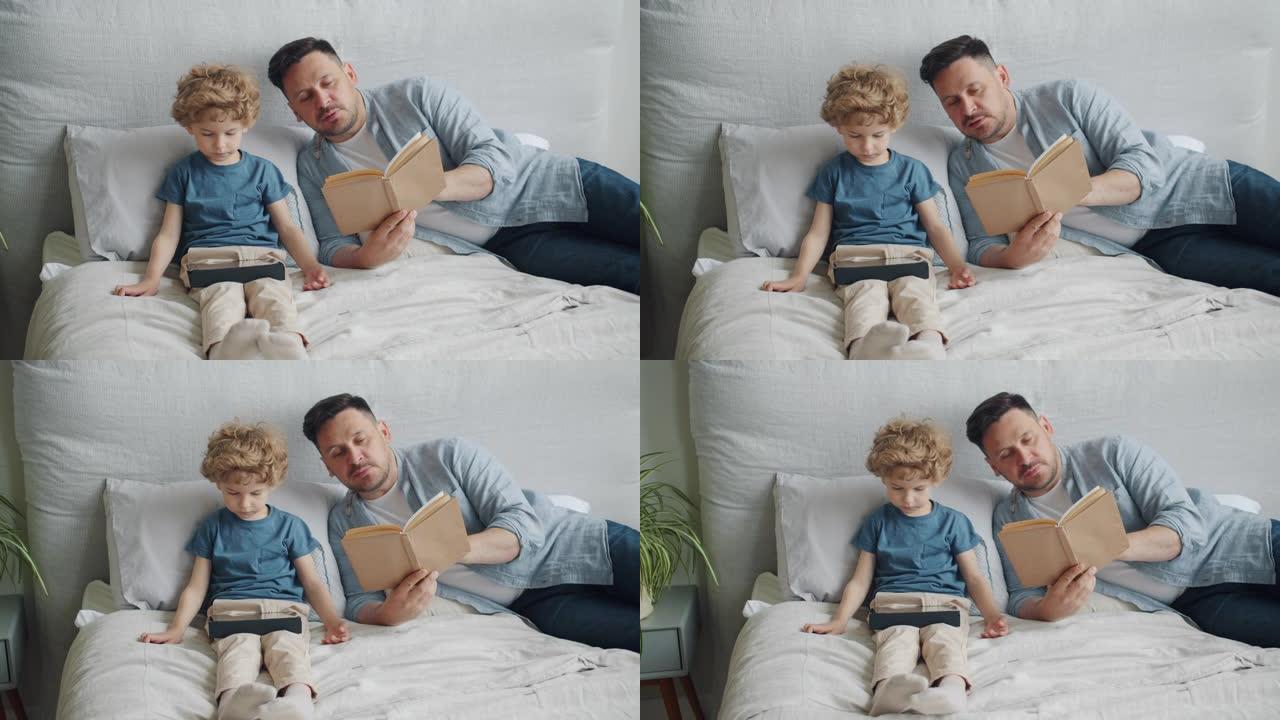 年轻人的父亲在孩子在床上使用平板电脑时向小男孩读书