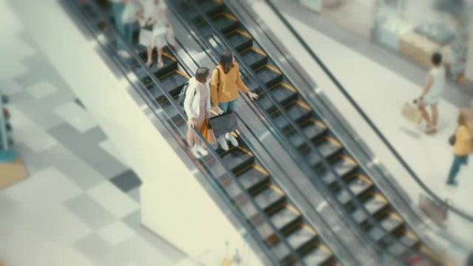 购物中心自动扶梯上亚洲女性的高角度视图