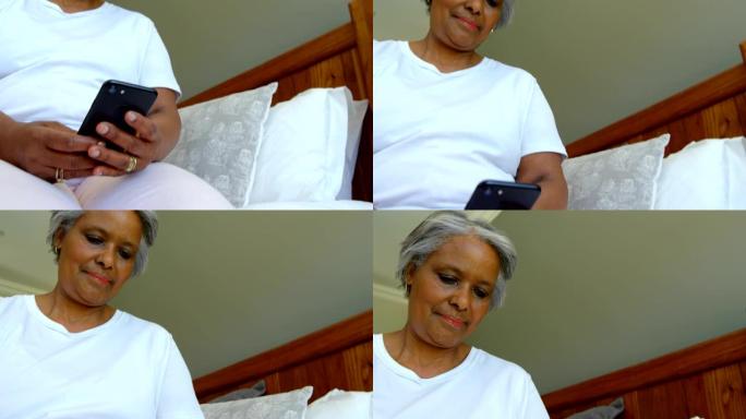 老年黑人女性坐在床上，在舒适的家庭中使用手机的低角度视角4k