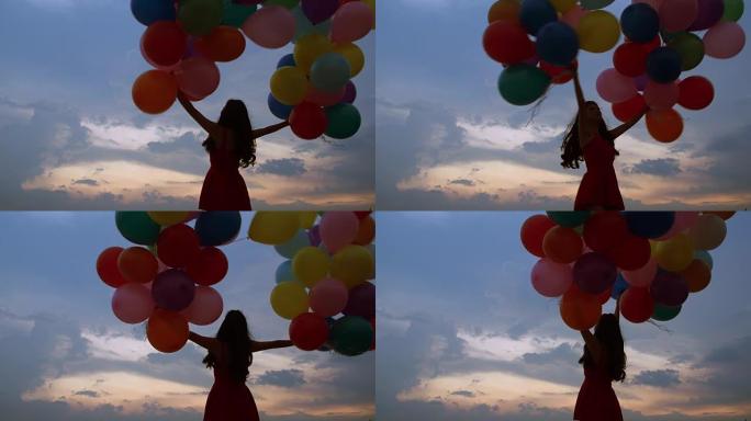 一个飞行的年轻女孩的剪影，气球在日落时蓝天的背景下。