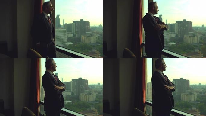 一个自信的高级商人站在办公室窗户附近的肖像。