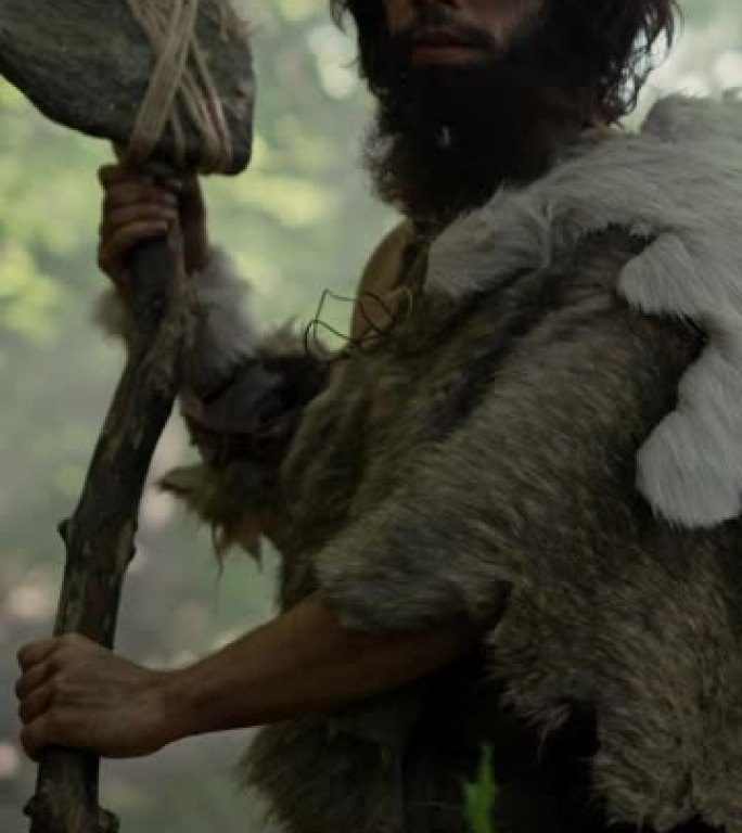 原始穴居人的肖像在史前森林中穿着动物皮和毛皮，用石尖矛狩猎。尼安德特人用原始工具清理。垂直屏幕9:1