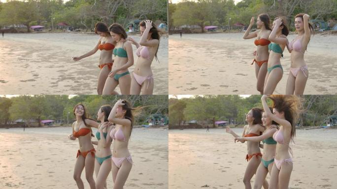 一群穿着比基尼的快乐女孩朋友在海滩上散步，快乐的女性团体游客在暑假。慢动作。