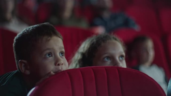男孩和女孩躲在电影院的座位后面