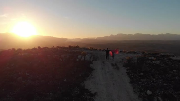 年轻夫妇在黄昏时分奔向山顶的公路旅行