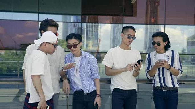年轻的亚洲成年男子在街上闲逛看手机