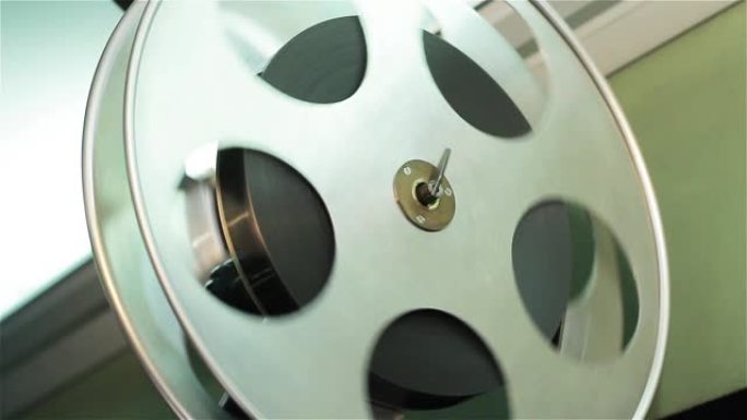 在电影院里播放的旧电影放映机。带有电影的卷轴的特写镜头。