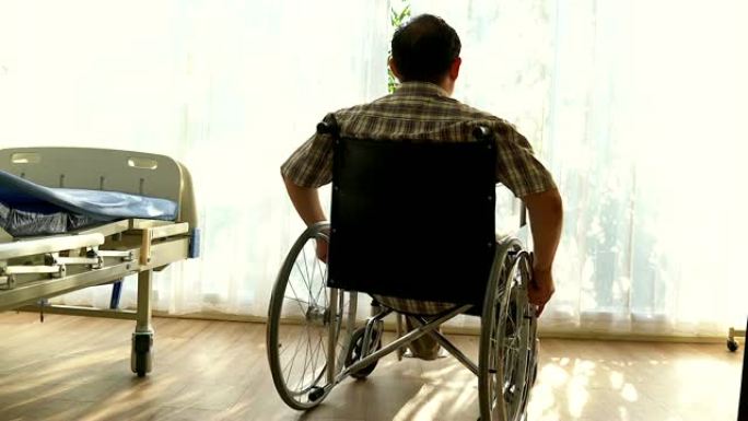 一名残疾人坐在轮椅上。他把手放在方向盘上。