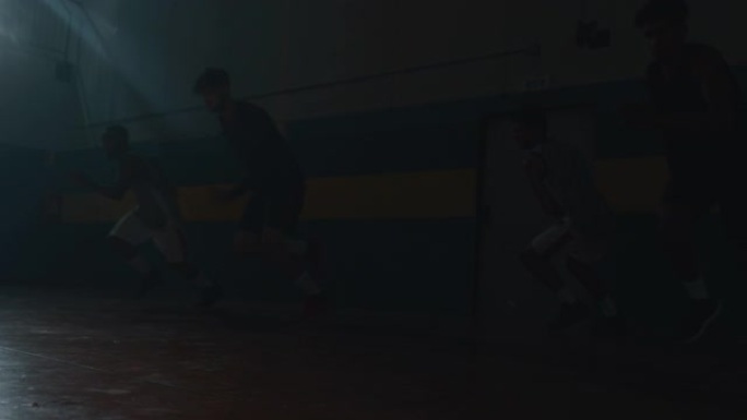 年轻职业男球员的电影慢动作镜头正在健身房练习艰苦的篮球锻炼