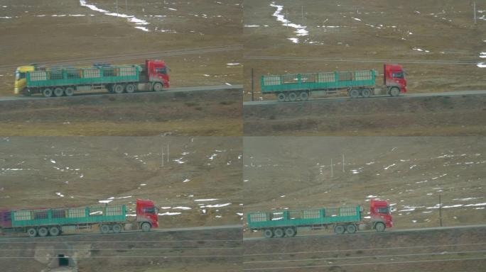 带空拖车的旧红色卡车，用于运输牲畜，沿着风景秀丽的道路行驶