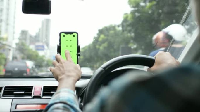 驾驶员在汽车中使用带有绿屏的智能手机