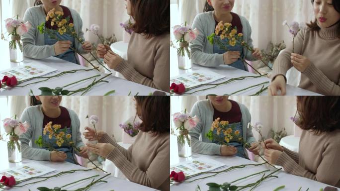 年轻的花店正在训练她的朋友如何制作花束