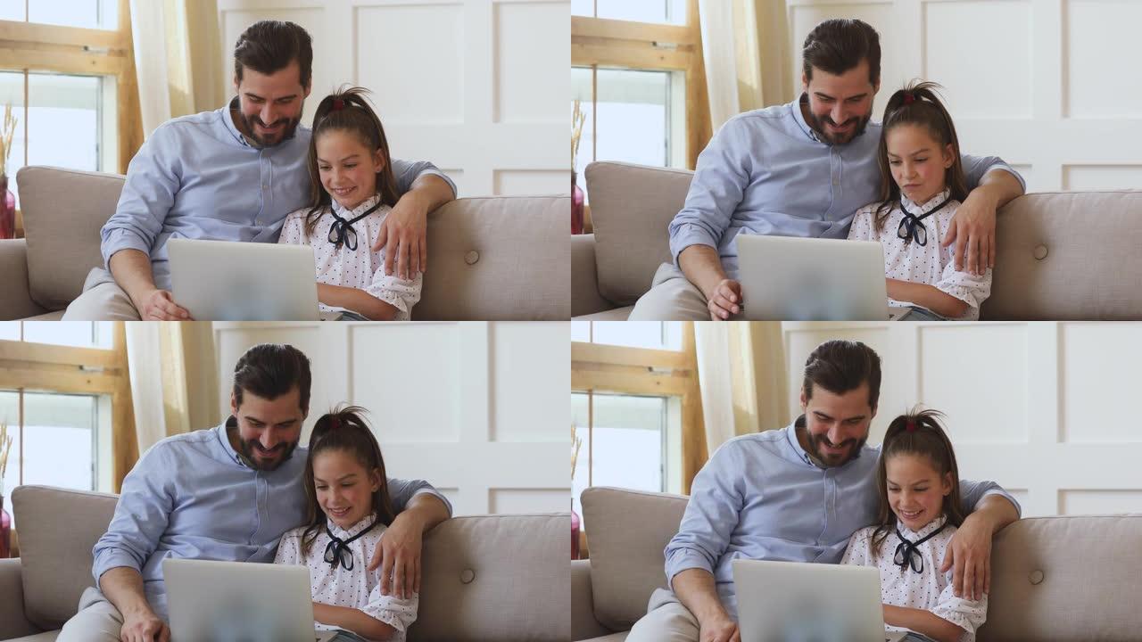 可爱的女儿和父亲玩得开心，用笔记本电脑看视频