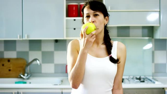 一个夏天的下午，一个年轻的女孩吃了一个新鲜的青苹果来保持健康，尊重他的饮食和微笑