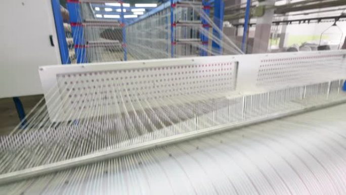 一串白线正在迅速重新定位。纺织厂设备。