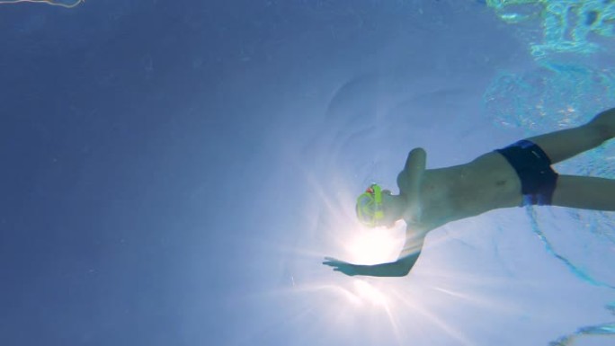 一个戴着潜水面具的男孩的水下镜头