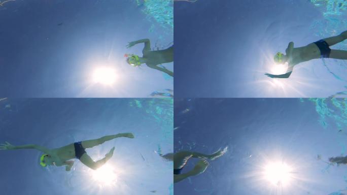 一个戴着潜水面具的男孩的水下镜头