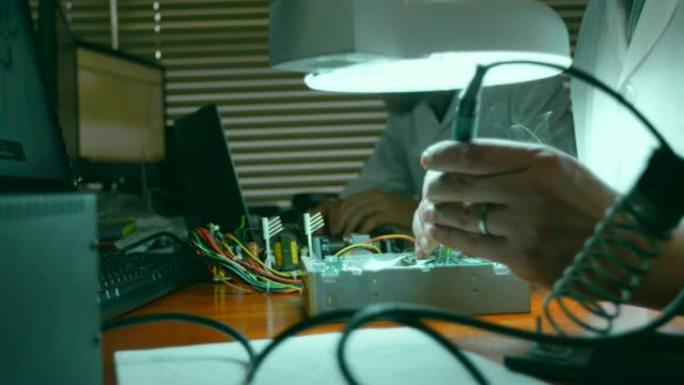 男性机器人工程师在4k办公桌上组装电路板