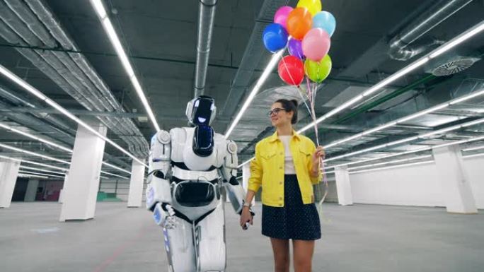 拿着气球和机器人的女孩牵着手走在房间里。