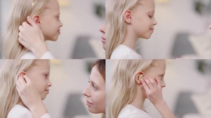 母亲给小女孩戴上助听器