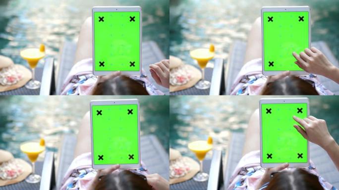 年轻女子放松游泳池上的数字平板电脑，色度键-垂直