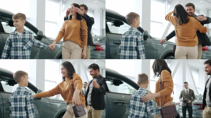 幸福的女人拥抱丈夫和儿子在经销店买新车的慢动作