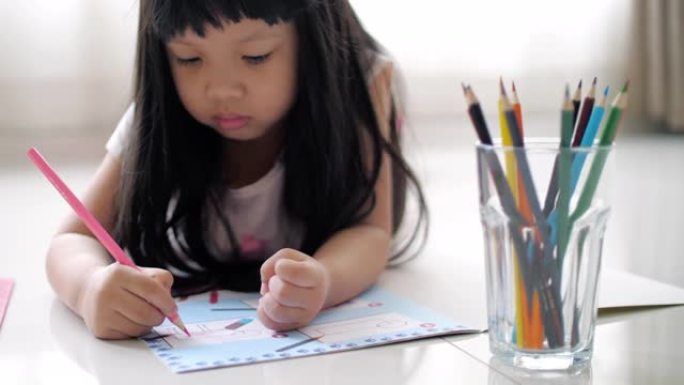 小女孩在绘图本上写作，在家工作
