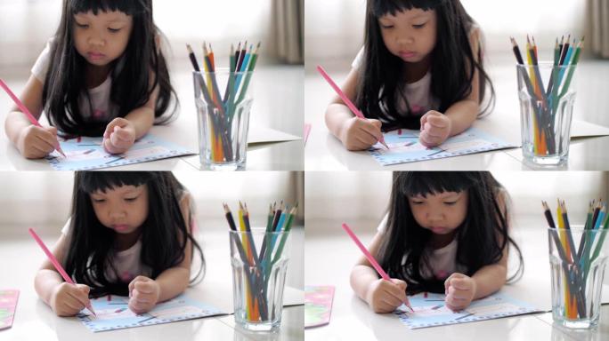 小女孩在绘图本上写作，在家工作