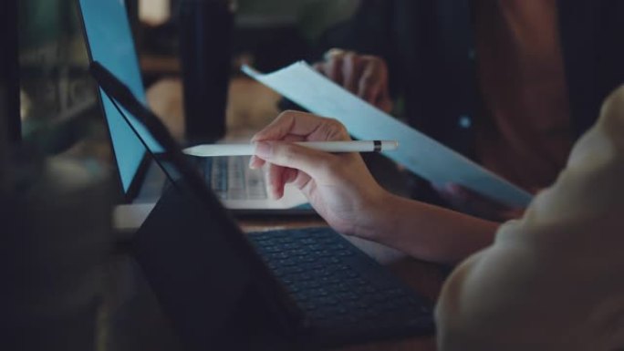男人和女人晚上在咖啡馆和数字平板电脑一起工作。