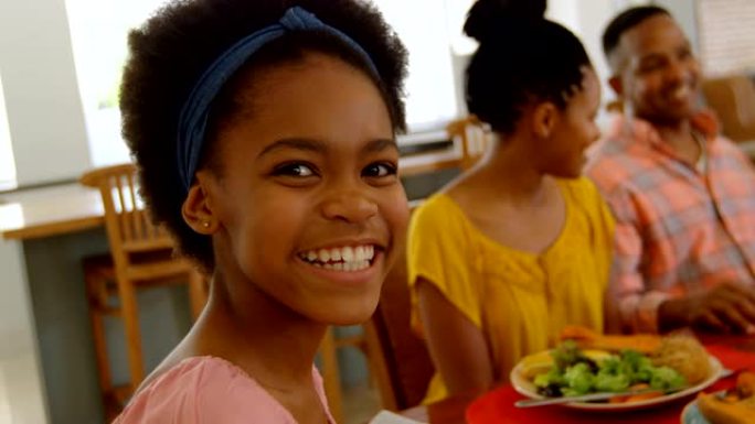 黑人女孩在舒适的家庭4k餐桌上与家人一起吃饭的前视图