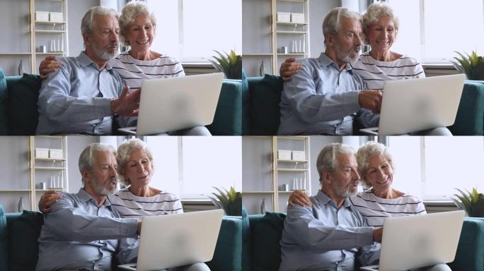 老年家庭祖父母夫妇使用笔记本电脑聊天坐在沙发上