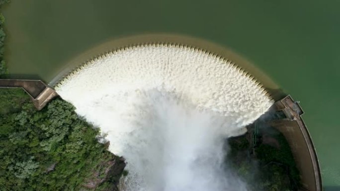 4k空中缩小在南非皮纳尔斯河上的Roodeplaat大坝混凝土拱上涌出的水的视图