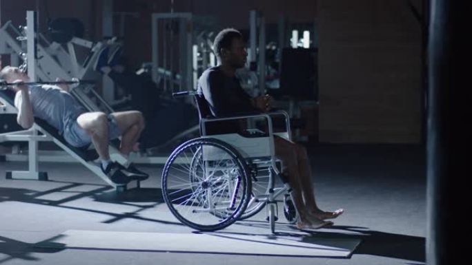 轮椅男子坐在其他人锻炼时