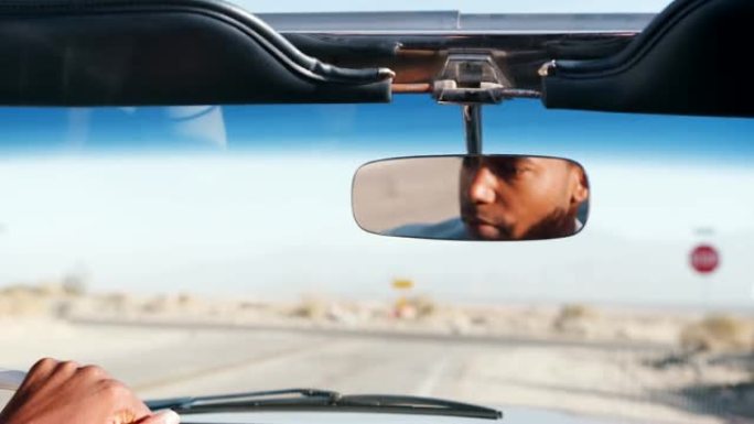 年轻的黑人驾驶敞车，在后视镜中看到