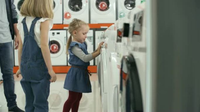 男人和两个顽皮的小女孩一起选择洗衣机