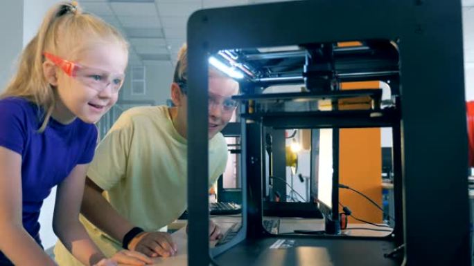 Samrt儿童观看现代3D打印机工作。回到学校的概念。