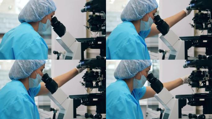 女科学家，医学实验室工作人员正在用显微镜观察望远镜