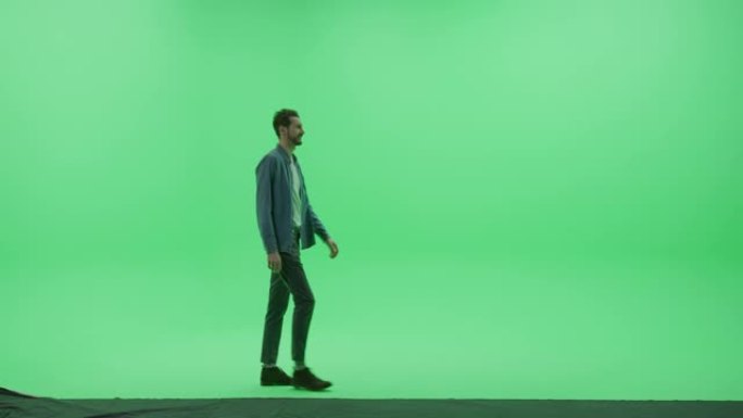 绿屏色键工作室: 穿着休闲服的强壮英俊的微笑男人从左到右穿过房间。侧视图摄像机拍摄