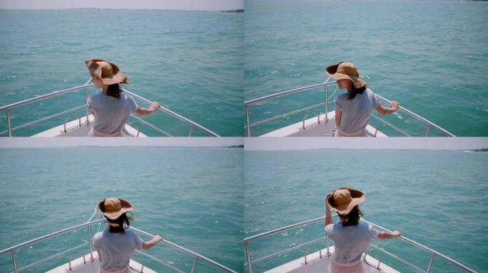 快乐成功的女性旅行者在船鼻前享受豪华阳光游艇海上游览的惊人后景照片。
