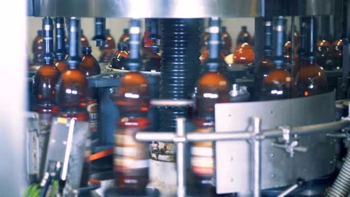 装满啤酒的瓶子在工厂机器中旋转