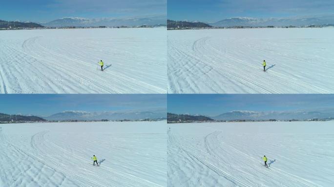 空中: 在白雪中沿着小径滑雪的活跃女性身后飞行。
