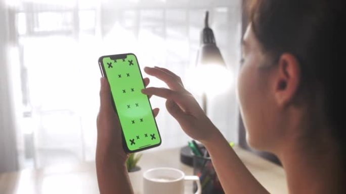 亚洲女性在家使用绿屏智能手机